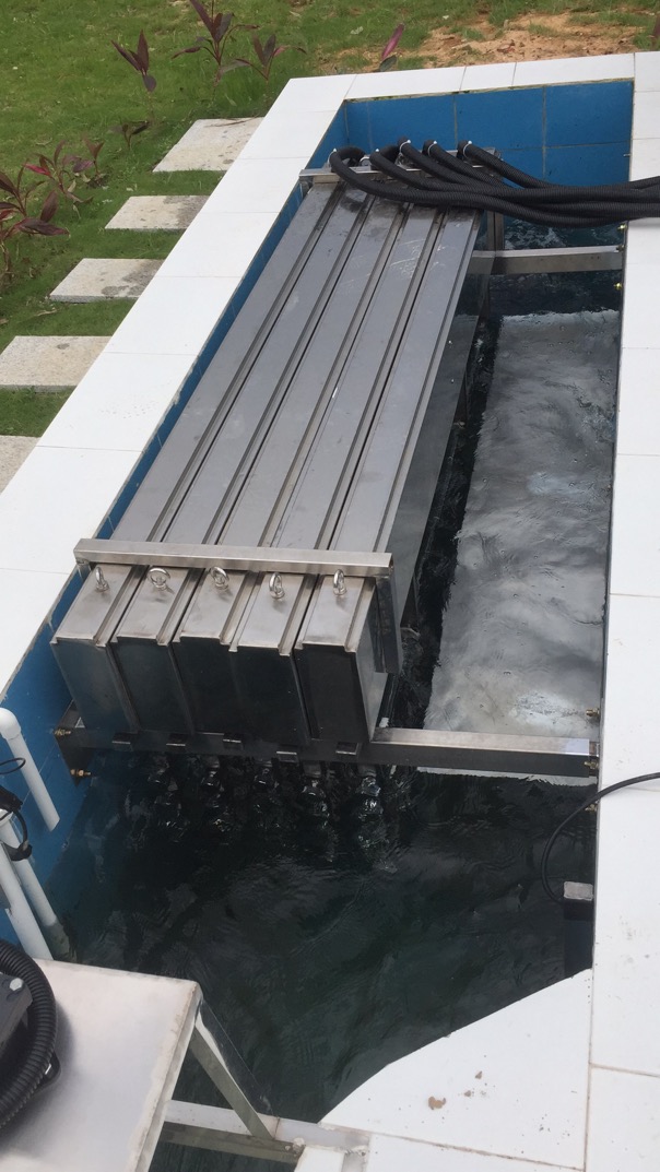 Banks of stainless steel UV modules mounted in a municipal wastewater open channel
