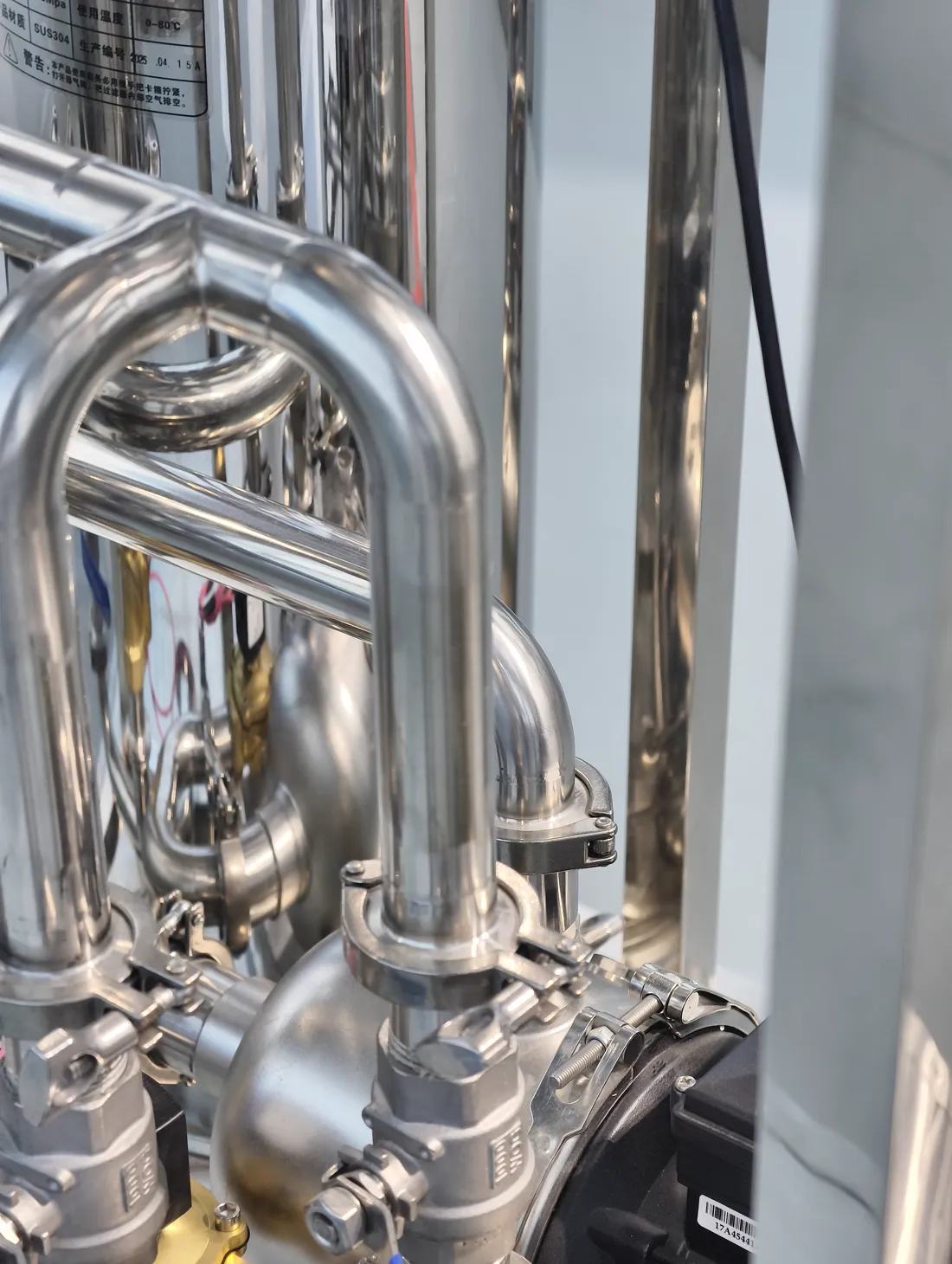 Polished stainless-steel piping and pump manifold on a KONCHE water treatment system